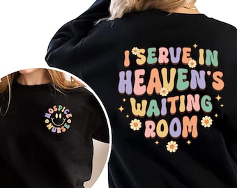 May include: Black sweatshirt with the text "I serve in Heaven's waiting room" in rainbow colors with daisy flowers. The front of the sweatshirt has a small smiley face with the text "Hospice Nurse" in a circle.