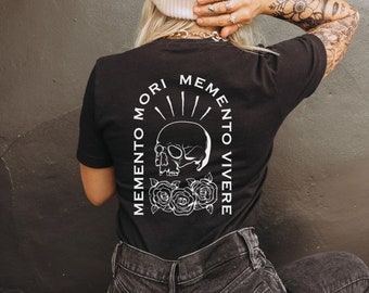 May include: Black t-shirt with a white skull and roses graphic and the text "Memento Mori Memento Vivere".