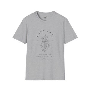 May include: A gray t-shirt with a black floral design and the text "AMOR FATI" in a circle. The text below the design reads "LOVE YOUR FATE WHICH IS IN FACT YOUR LIFE FRIEDRICH NIETZSCHE".
