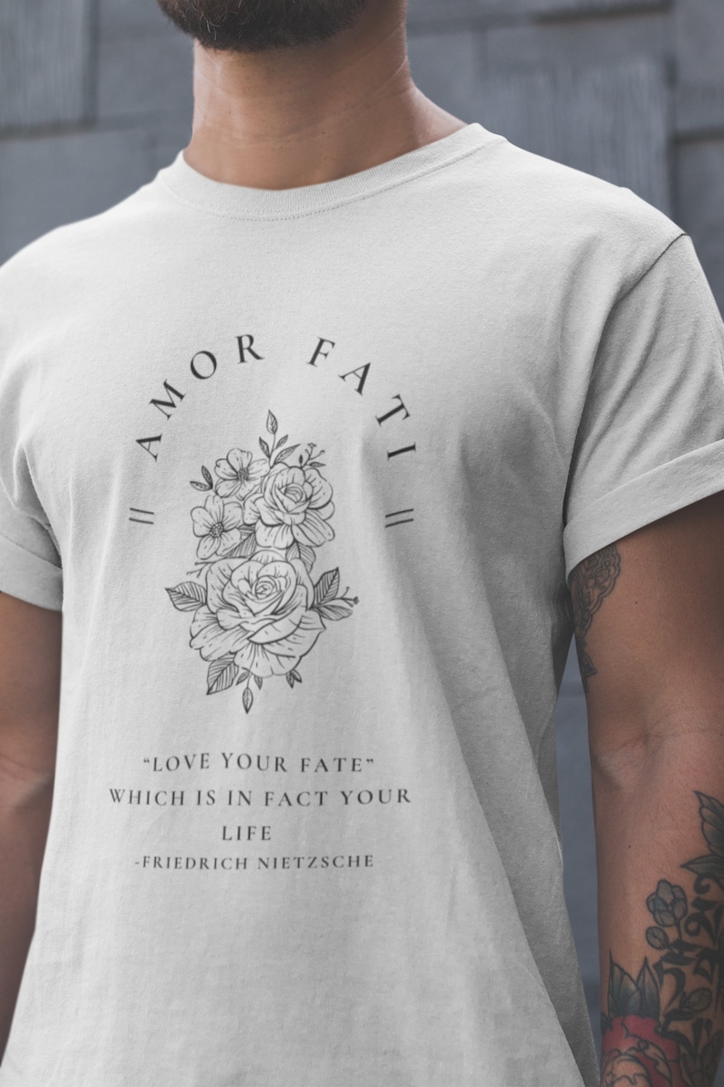 May include: A white t-shirt with a black floral design and the text "|| AMOR FATI ||" and "LOVE YOUR FATE" WHICH IS IN FACT YOUR LIFE -FRIEDRICH NIETZSCHE"