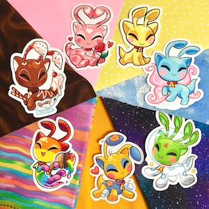 May include: A collection of colorful stickers featuring cartoon creatures in various poses. One brown creature is in a sundae, a pink one holds a rose, and others are in different colors. The stickers are on a colorful background.