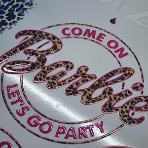 May include: A pink and brown circle sticker with the text "Come on Barbie, let's go party" in a leopard print font.