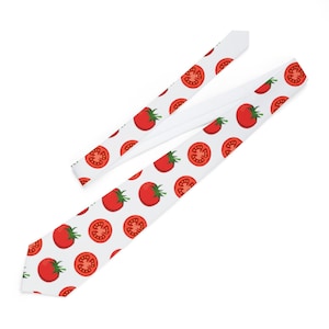 May include: A white necktie with a repeating pattern of red tomatoes. The tomatoes are whole and sliced in half.