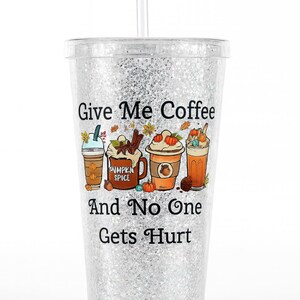 Puede incluir: Vaso transparente lleno de purpurina con pajita, con un gráfico colorido de cuatro bebidas de café con adornos temáticos de otoño. El texto "Give Me Coffee And No One Gets Hurt" está impreso en la parte delantera.