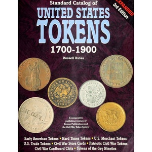 May include: A book cover with a red background and gold lettering. The title is "Standard Catalog of United States Tokens 1700-1900" by Russell Rulau. The cover features images of five different tokens, including a Liberty Head token, a New York Grand Canal token, and a token with the inscription "H. Gay."