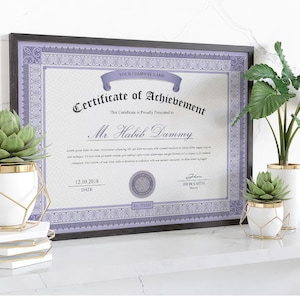 May include: A framed certificate of achievement with a purple border and text. The certificate is displayed with decorative plants in white pots with gold accents. The plants are on a white surface.