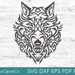 Op de afbeelding: Zwarte en witte silhouet van een wolfskop in tribale stijl. De wolfskop is naar voren gericht met zijn bek open en zichtbare tanden. Het ontwerp is ingewikkeld en gedetailleerd.
