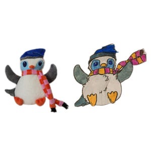 Puede incluir: Dos juguetes de ping&uuml;ino, uno de peluche y otro dibujado. El ping&uuml;ino de peluche tiene un cuerpo blanco, alas grises, un gorro y bufanda azules. El dibujo muestra un ping&uuml;ino con gorro y bufanda azules. Ambos tienen patas naranjas.