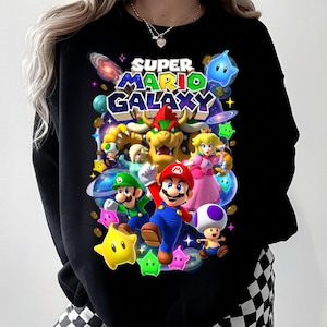 Puede incluir: Un letrero de madera hecho a mano con la palabra "Bienvenido" en una fuente juguetona. El letrero est&aacute; pintado de blanco con un acabado envejecido y presenta un dise&ntilde;o floral en tonos rosas y verdes. Mide aproximadamente 30 cm de ancho.