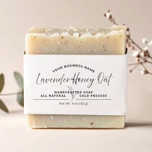 May include: A bar of handcrafted soap with a white label. The label reads "Lavender Honey Oat" and "All Natural Cold Process." The soap weighs 113 g. The soap is light beige with small flecks.