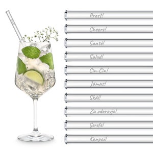 Könnte beinhalten: Set mit 10 Glas-Trinkhalmen mit verschiedenen Toastsprüchen in weißer Schrift. Die Strohhalme sind klar und haben eine glatte, polierte Oberfläche. Die Toasts beinhalten "Prost!" "Cheers!" "Santé!" "Salud!" "Cin-Cin!" "Jámas!" "Skål!" "Za zdorovje!" "Şerefe!" und "Kanpai!"