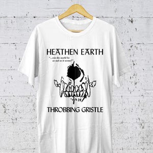 May include: White t-shirt with a black graphic print of a skull with teeth and the text "HEATHEN EARTH" and "...can the world be as sad as it seems?" above the skull and "THROBBING GRISTLE" below the skull.