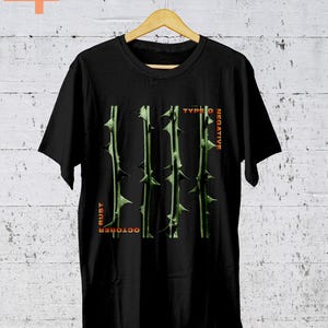 Może przedstawiać: Czarny T-shirt z grafiką zielonych, kolczastych łodyg i tekstem "Type O Negative" i "October Rust" w kolorze pomarańczowym.