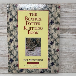 May include: The Beatrix Potter Knitting Book by Pat Menchini, featuring a yellow cover with a colourful illustration of a mouse knitting. The book is published by F. Warne & Co. and includes over 50 knitting patterns.