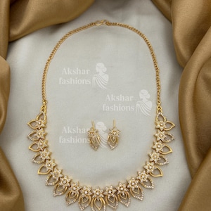 Pode incluir: Caneca de cerâmica branca com uma alça preta e a frase "But First, Coffee" em preto. A caneca está em um fundo desfocado, sugerindo um ambiente acolhedor.