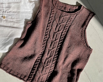 Può includere: Un maglione di lana marrone senza maniche con un motivo a treccia.