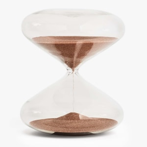 May include: A clear glass hourglass with brown sand. The sand is flowing from the top bulb to the bottom bulb.