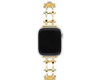 May include: A gold-toned Apple Watch band with a chain-link design and colorful gemstones. The band is made of metal and has a polished finish.