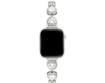 May include: A silver Apple Watch with a black face and a silver band with heart-shaped crystals.