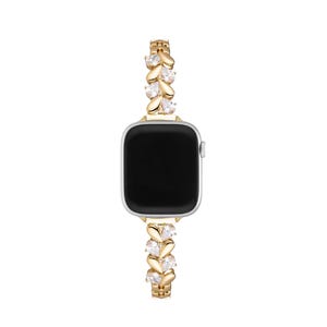 May include: Gold Apple Watch band with clear crystal embellishments in a leaf design.