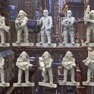 Peut inclure: Un ensemble de dix figurines miniatures non peintes, représentant une variété de personnages, y compris des humanoïdes et des extraterrestres. Les figurines sont posées dans diverses positions d'action, tenant des armes et des outils. Les figurines sont en plastique gris et sont prêtes à être peintes.