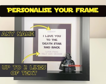 May include: A black frame with a white mat and a personalized message inside. The message reads "Daddy I love you to the Death Star and back Love from Tilly and George". A Lego Darth Vader figure is in the bottom right corner of the frame.