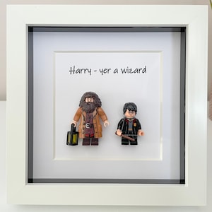 Könnte beinhalten: Eine weiße Keramik-Tasse mit schwarzem Henkel und dem Text "But First, Coffee" in schwarzer, fetter Schrift. Die Tasse steht auf einer Holzoberfläche. Die Tasse ist etwa 10 cm hoch.