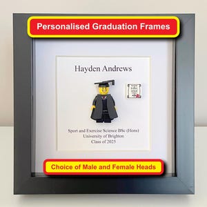 May include: A framed graduation display with a Lego figure in a graduation gown and cap. The frame includes the text "Personalised Graduation Frames", the graduate's name, degree details, and "Choice of Male and Female Heads".