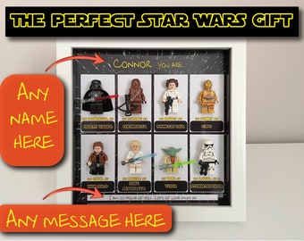 May include: A white framed shadow box with a black background and a grid of Star Wars characters. The characters are Lego minifigures. The text "CONNOR YOU ARE..." is at the top of the box. The text "I AM SO PROUD OF YOU. LOTS OF LOVE MUM XXX" is at the bottom of the box.