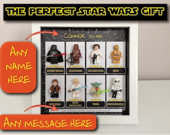 May include: A framed Star Wars-themed gift featuring Lego figures of Darth Vader, Chewbacca, Princess Leia, C-3PO, Han Solo, Luke Skywalker, Yoda, and a Stormtrooper. The frame includes customizable text areas for a name and message, with the text "THE PERFECT STAR WARS GIFT" at the top.