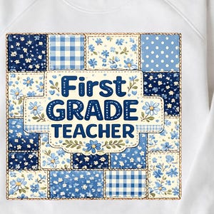 Peut inclure: Un sweat-shirt blanc à manches longues avec un motif central de patchwork bleu et blanc. Le graphisme présente divers motifs floraux, à pois et à carreaux vichy, avec le texte First GRADE TEACHER écrit en lettres bleu foncé.