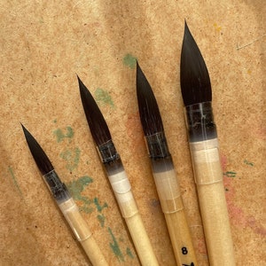 May include: Four Roubloff brand paint brushes with black bristles and wooden handles. The brushes are labelled with their sizes: 4, 6, 8, and 10.