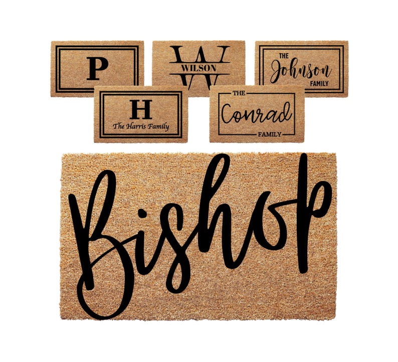 May include: A collection of rectangular tan coir doormats featuring black text and borders. The designs include single letters, family names like Wilson, Johnson, Harris, Conrad, and a large script font displaying the name Bishop.