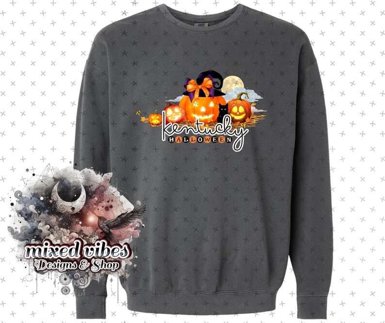 May include: A dark gray sweatshirt with a graphic print of pumpkins and a black cat. The text "Kentucky Halloween" is printed below the pumpkins.