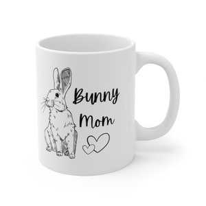 White ceramic mug with black design of rabbit and text that says "bunny mom" with two hearts.  Right handed view with handle on the right.