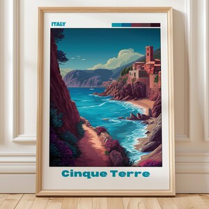 May include: A framed travel poster featuring a stylised illustration of the Cinque Terre coastline in Italy. The artwork depicts a coastal path, turquoise water, rocky cliffs, and buildings, with the text ITALY and Cinque Terre printed.