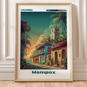 Puede incluir: Impresión artística enmarcada que presenta una colorida escena callejera en Mompox, Colombia. La obra de arte representa edificios en tonos azules, amarillos y rojos, con una torre de iglesia al fondo. Incluye las palabras "Colombia" y "Mompox".