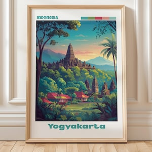 Op de afbeelding: Ingelijste kunstprint met een illustratie van Yogyakarta, Indonesië. Het kunstwerk toont een tempelcomplex in weelderig groen, met de teksten "Indonesia" en "Yogyakarta" in turquoise. De scène is omlijst door een houten lijst.