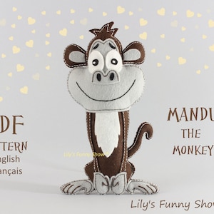 May include: PDF pattern for a felt monkey toy named "Mandu the Monkey". The pattern is available in English and French. The monkey is brown with a gray face and a white beard. The pattern is from Lily's Funny Show.