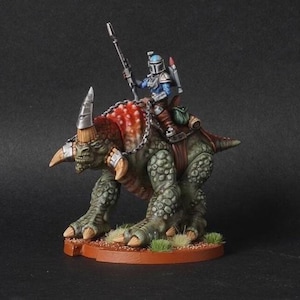 May include: A green and brown, reptilian creature with horns and a chain around its neck. A blue and silver armored figure with a spear rides on the creature's back.