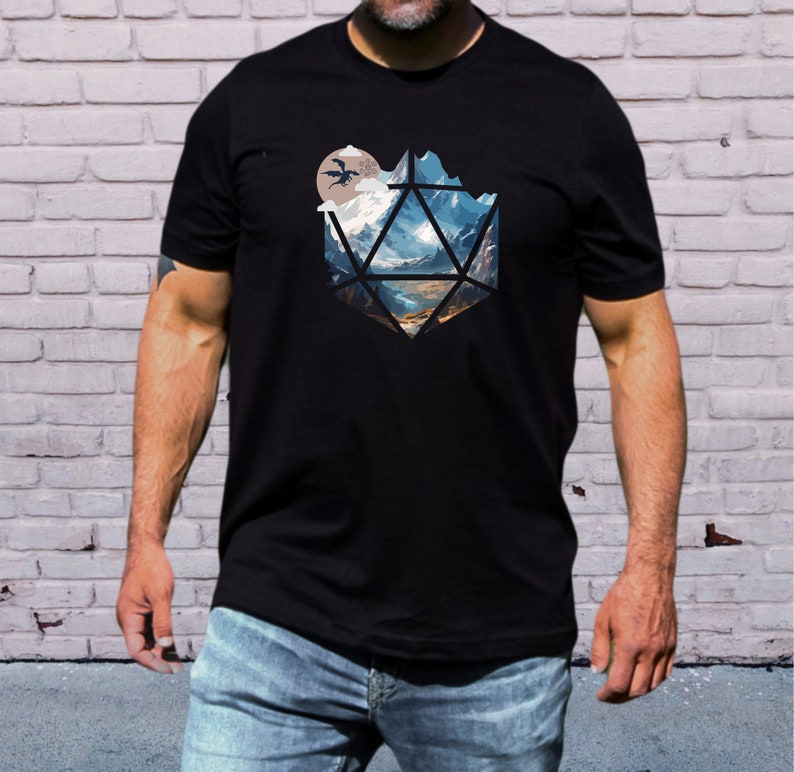 Pode incluir: Uma camiseta preta com um gr&aacute;fico de uma paisagem montanhosa dentro de uma forma geom&eacute;trica, que se assemelha a um dado. O gr&aacute;fico apresenta uma lua e dois drag&otilde;es voando.