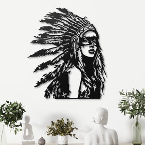 Può includere: Arte da parete in metallo nero che raffigura una donna con un copricapo di piume. La donna ha i capelli lunghi e guarda a destra. L'opera è montata su una parete bianca.