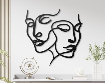 Abstracte gezichten, metalen wanddecoratie, moderne minimalistische lijnsculptuur.