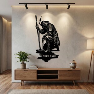 May include: Black metal wall art depicting a kneeling samurai warrior holding a katana. The artwork features intricate details of the samurai's armor and helmet. The text "YOUR NAME" is below the samurai.