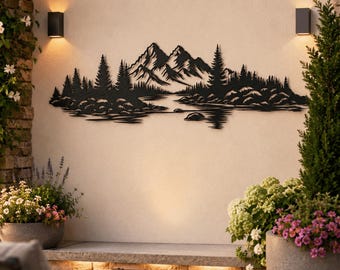 May include: A black metal wall art piece featuring a detailed silhouette of a mountain range, a forest of pine trees, and a calm lake. The design is horizontally oriented, showcasing sharp peaks, dense tree lines, and rocky shorelines.