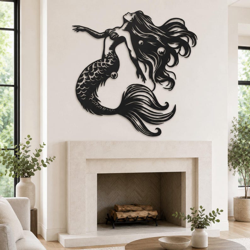 Puede incluir: Una pieza de arte mural de metal negro que representa una sirena con cabello largo y fluido y una cola detallada. La silueta muestra a la sirena en una pose de nado con los brazos extendidos hacia arriba, con detalles recortados.