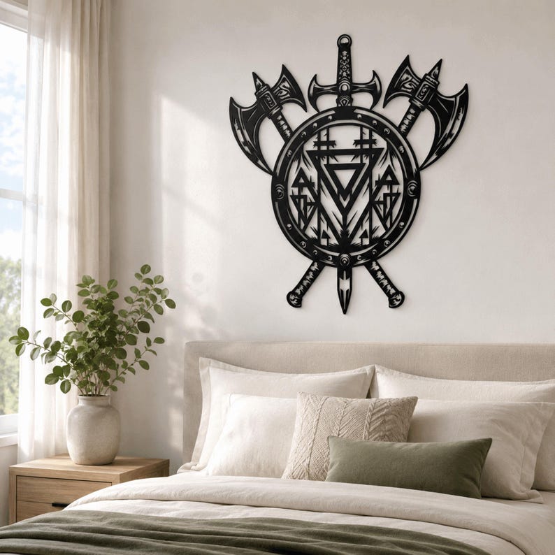 May include: A black metal wall art piece featuring a central circular shield design with intricate geometric patterns, flanked by two crossed battle axes and a vertical sword positioned behind the shield, creating a symmetrical warrior-themed display.