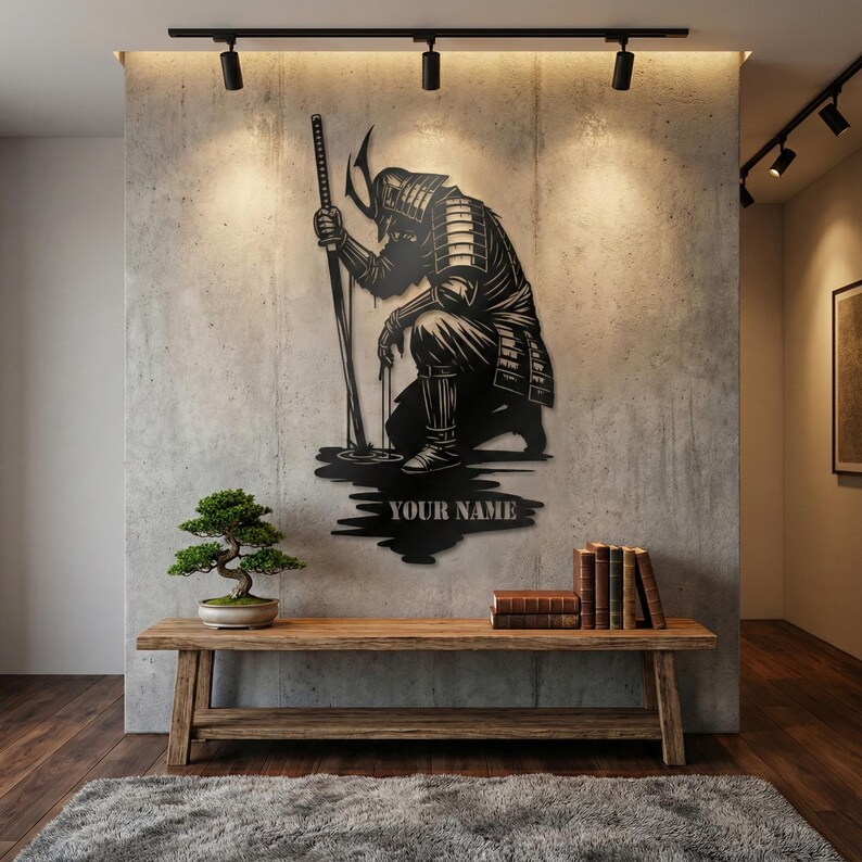 May include: Black metal wall art depicting a kneeling samurai warrior holding a katana. The artwork is mounted on a concrete wall, with the text "YOUR NAME" below the figure. A wooden bench with a bonsai tree and books is in front.