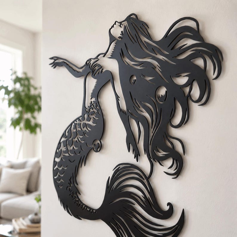 Puede incluir: Una pieza de arte mural de metal negro que presenta la silueta recortada de una sirena con cabello largo y fluido y una cola detallada. El dise&ntilde;o muestra a la figura extendiendo un brazo hacia arriba, con un acabado negro mate y plano.