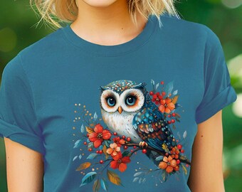 May include: A teal blue t-shirt with a graphic of a blue and white owl with red flowers. The text "Bella Canvas Heather Deep Teal" is in the bottom right corner of the image.